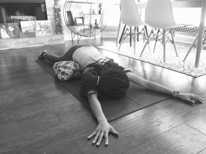 black and white image of women doing yoga with pillow under her