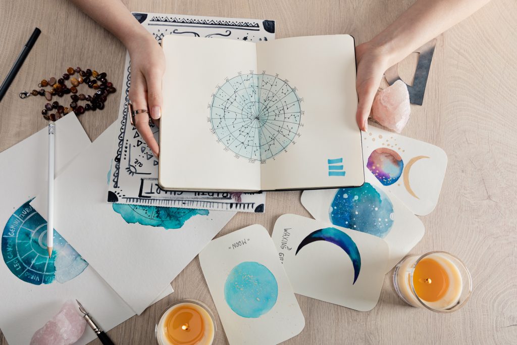 Astrologer's hands holding an astrology book open