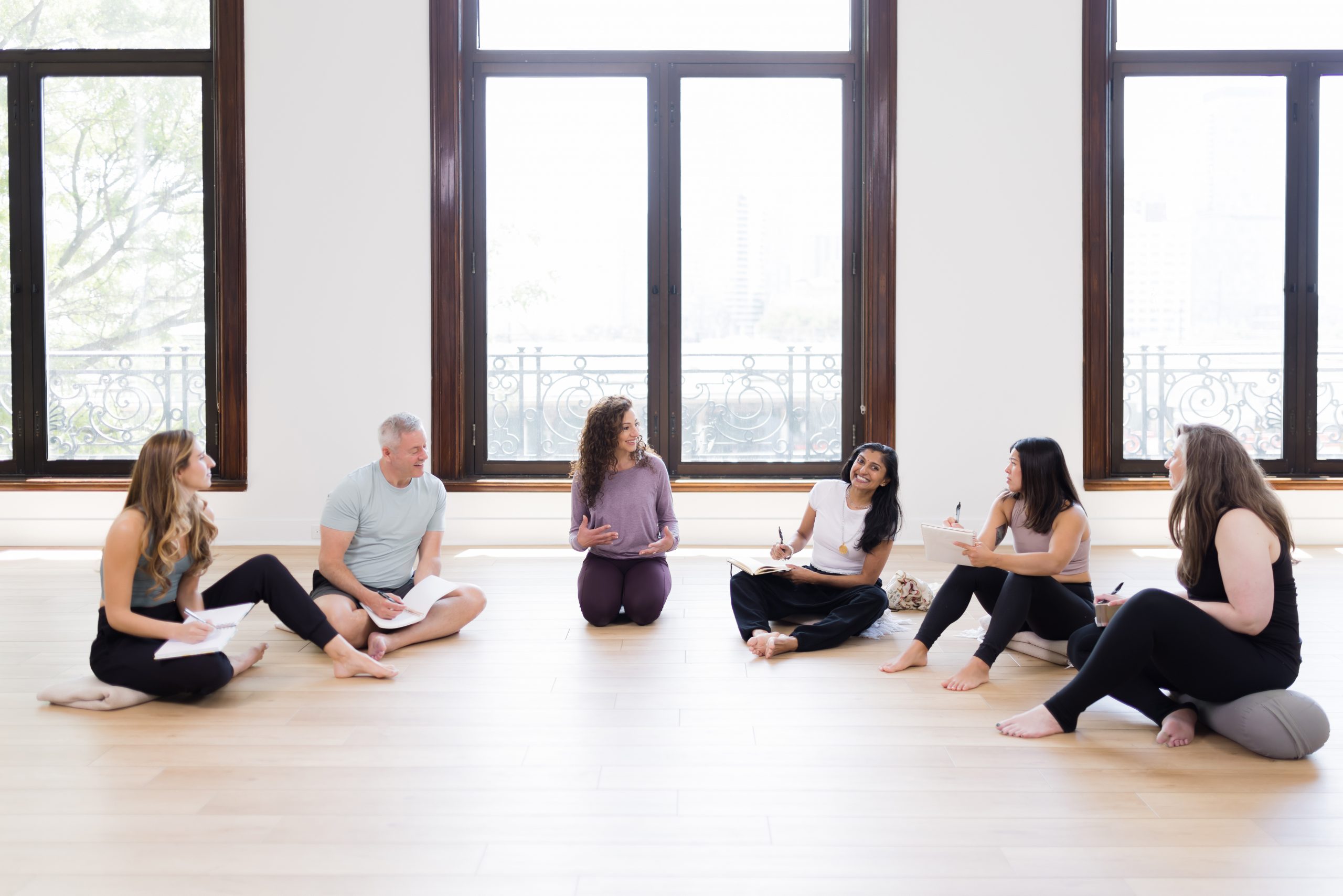 A group photo of YogaRenew's lead teachers conversing about mindfulness in a semi-circle