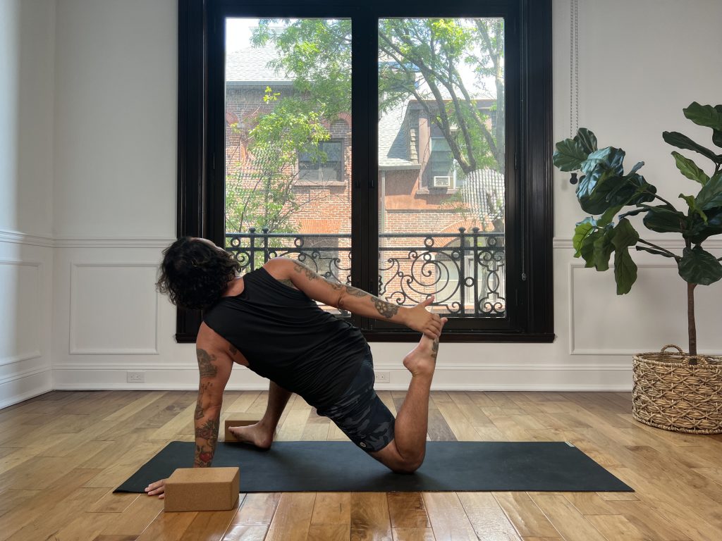 Man in lizard with quad opener on yoga mat