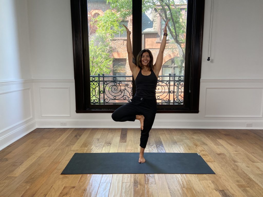 Girl in tree pose on a yoga mat