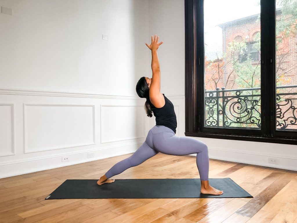 Girl in Warrior I on yoga mat