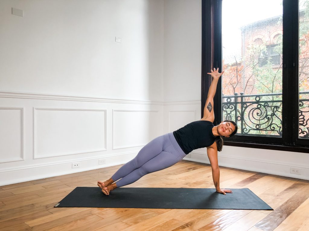 Person in a side plank pose on a yoga mat