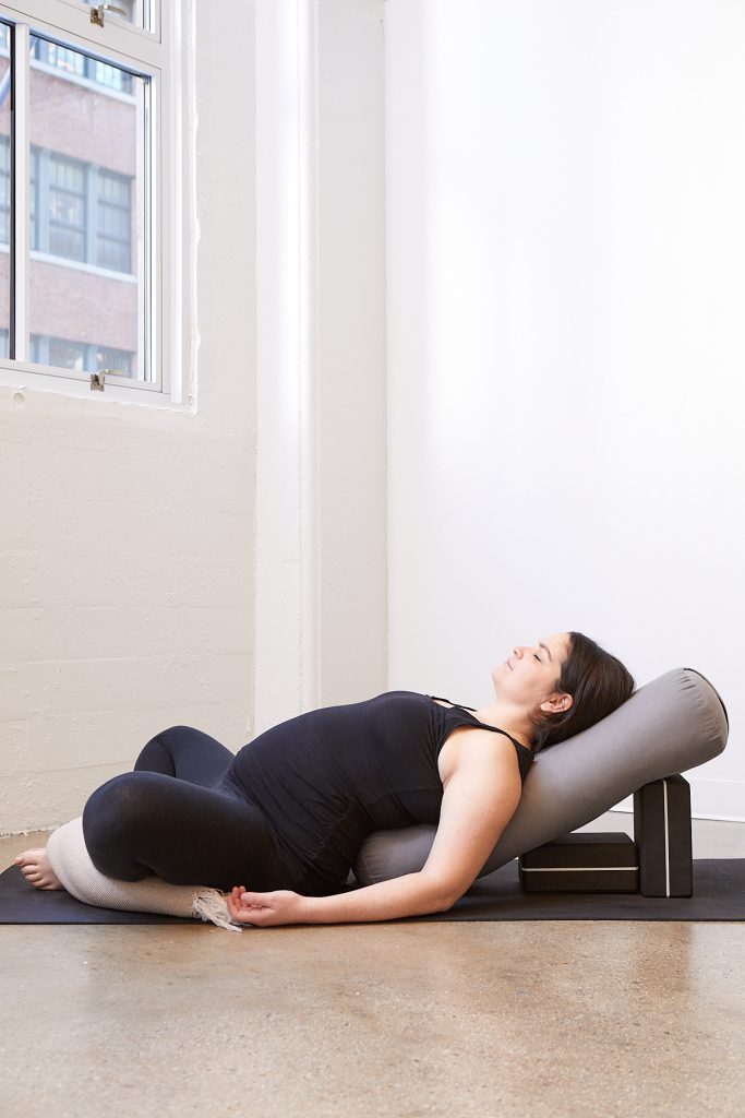 Pregnant yogi in Supta Baddha Konasana (reclined bound angle pose)